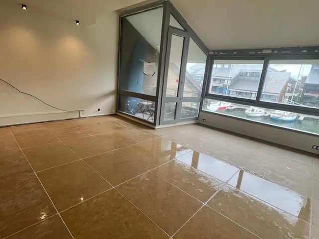 Grand carrelage brillant posé au sol d'une pièce à vivre — Mont-Saint-Aignan